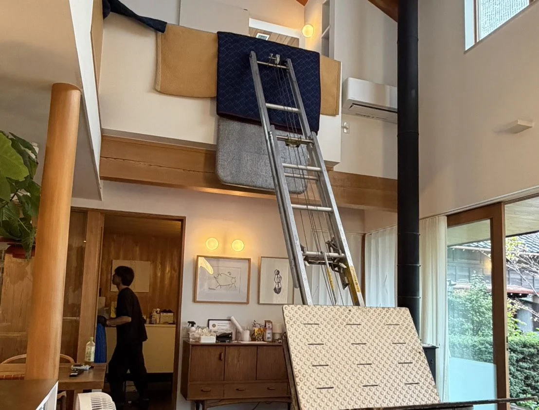 吹き抜けのある住宅で、養生した電動はしごを使って上階へ荷物を搬入する作業